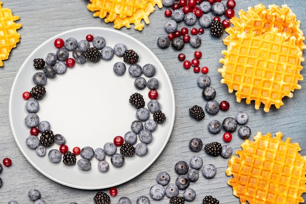 Bacche su un piatto grigio Cialde e frutti di bosco sul tavolo