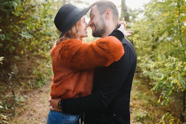 Baciare la giovane coppia innamorata nel parco d'autunno