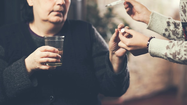 Badante femminile che dà la medicina al paziente della donna più anziana