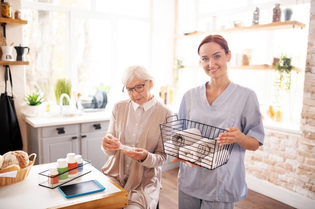 Badante femminile personale che sta vicino alla donna pensionata