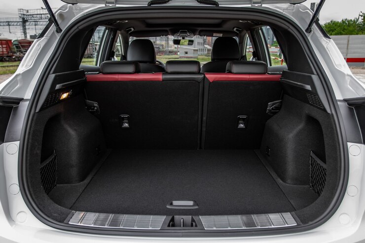 Foto bagagliaio per auto enorme, pulito e vuoto all'interno del suv compatto. vista posteriore di un'auto suv con bagagliaio aperto