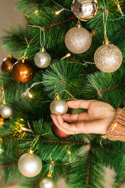 Bagattella della tenuta della mano della donna per l'albero di Natale