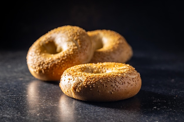 Bagel al forno con semi di sesamo sul tavolo nero