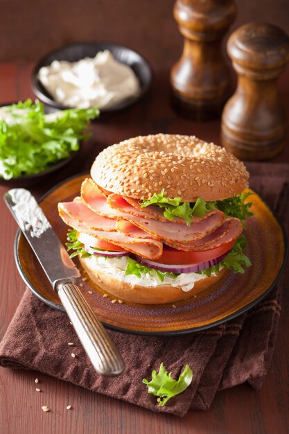 Bagel al prosciutto con crema di formaggio, pomodoro e cipolla