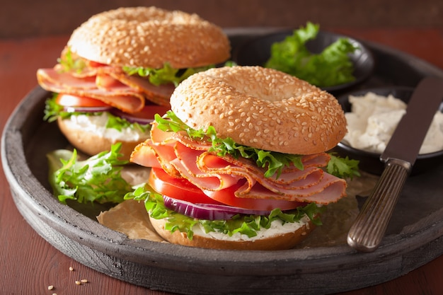 Bagel al prosciutto con crema di formaggio, pomodoro e cipolla