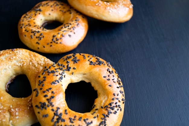 Bagel con semi di sesamo su sfondo nero