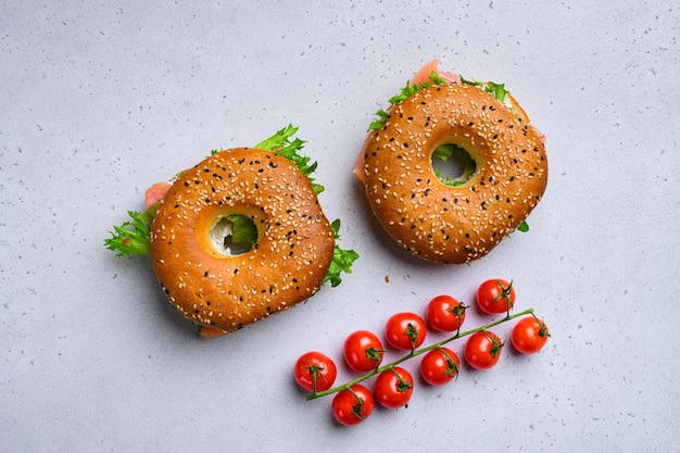 Bagel di formaggio cremoso e salmone affumicato su sfondo grigio tavolo in pietra vista dall'alto piatto