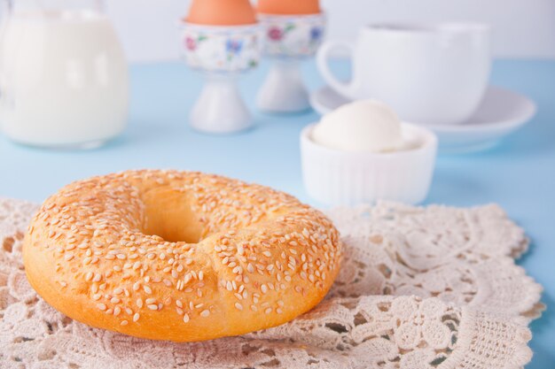 Bagel fresco sano su un tovagliolo bianco con una tazza di caffè