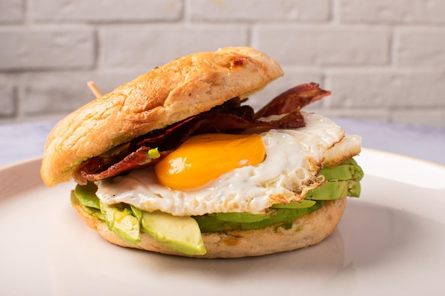 Bagel per brunch con pancetta e avocado all'uovo gourmet