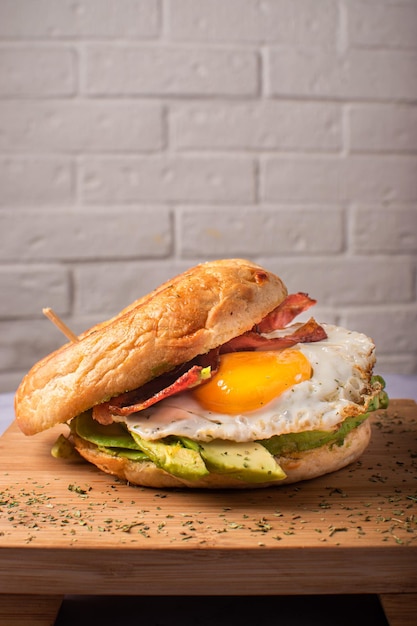 Bagel per brunch con pancetta e avocado all'uovo gourmet