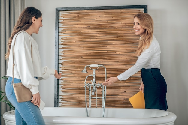 Bagno. Agente immobiliare che mostra un bagno a una cliente female