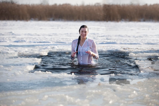 Bagno di rito ortodosso nella buca di ghiaccio Una donna si bagna in acqua ghiacciata