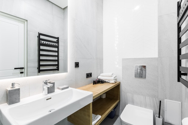 bagno moderno con doccia in un piccolo appartamento con piastrelle in marmo bianco