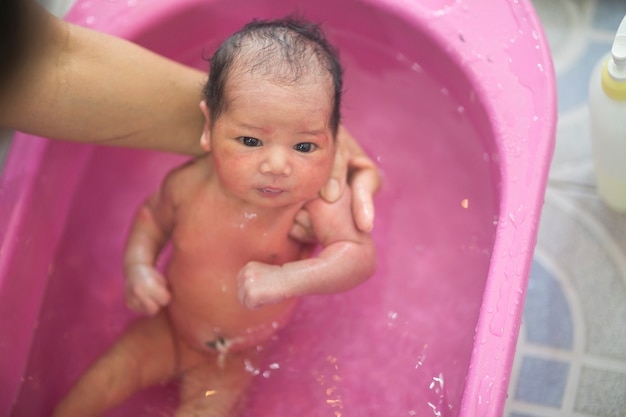 Bagno neonato in vasca bianca da madre