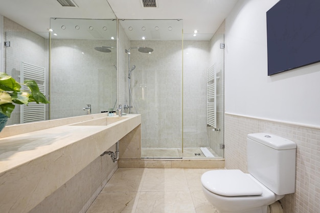 Bagno senza armadi con uno specchio che copre la parete, una cabina doccia con schermi e porte in vetro e un lavabo di design in marmo monoblocco