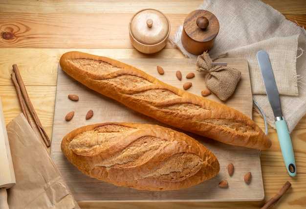 Baguette al forno e pane multicereali sul tavolo di legno marrone pronto a servire.