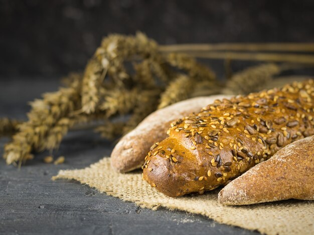 Baguette appena preparate su un pezzo di tela da imballaggio su un tavolo scuro con orecchie