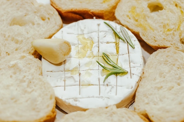 Baguette bianca tagliata a pezzi con olio d'oliva e Camembert sul tavolo
