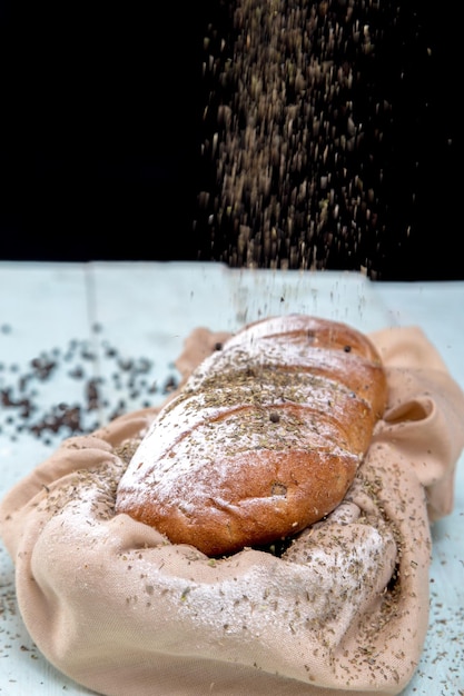 Baguette di pane francese su fondo di legno con erbe aromatiche