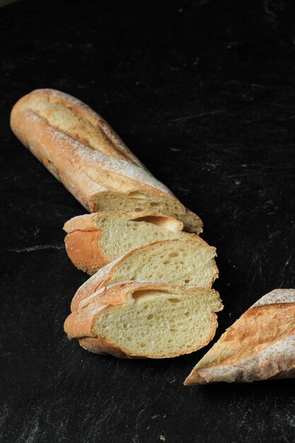 Baguette fette di pane morbido francese fresco isolato su sfondo nero Close up