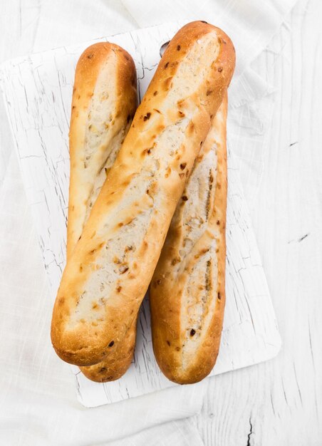 Baguette francesi su fondo di legno bianco