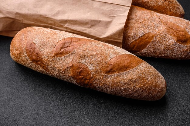 Baguette francesi su uno sfondo di cemento di consistenza scura Preparare deliziose bruschette a casa