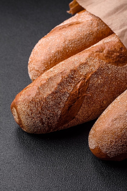 Baguette francesi su uno sfondo di cemento di consistenza scura Preparare deliziose bruschette a casa