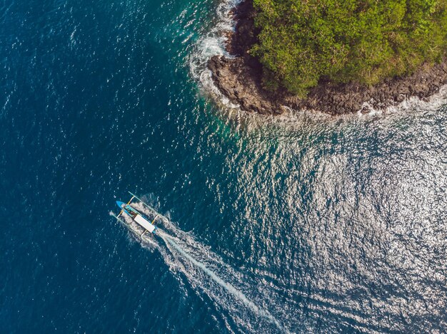 Baia del mare con acqua turchese e una piccola spiaggia bianca Splendida laguna e isola vulcanica ricoperte da una fitta foresta vista dall'alto