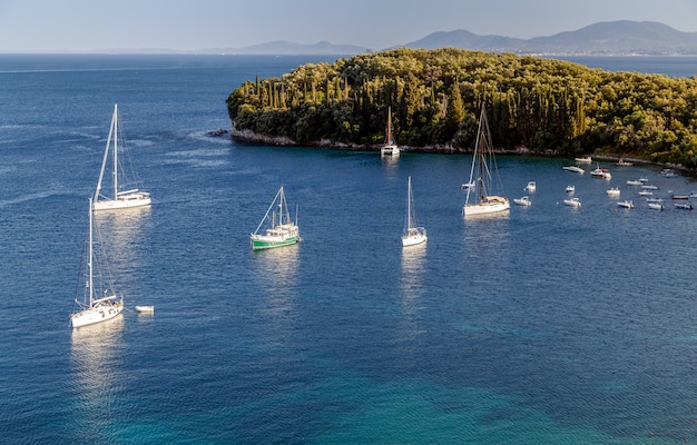 Baia del mare con yacht e barche in acque azzurre cristalline a Paleokastritsa Grecia