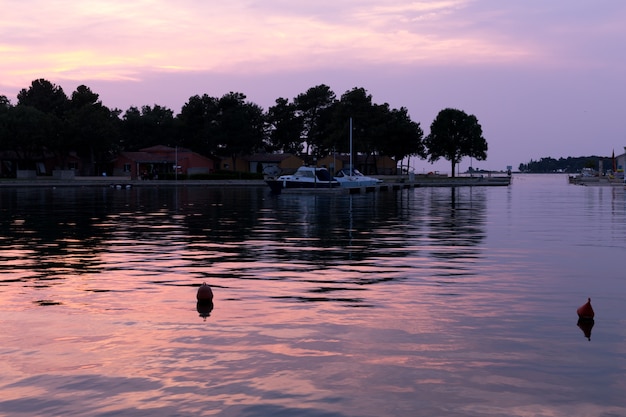 Baia di mare con yacht al tramonto