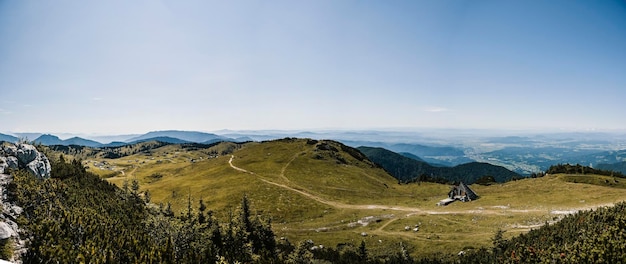 Baita di montagna rifugio o casa sulla collina Velika Planina prato alpino paesaggio Eco agricoltura Alpi di Kamnik Slovenia Grande altopiano Panorama banner