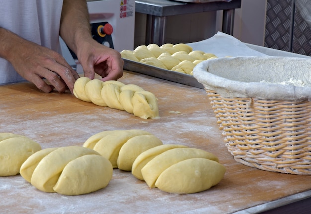 Baker che modella il pane intrecciato dolce