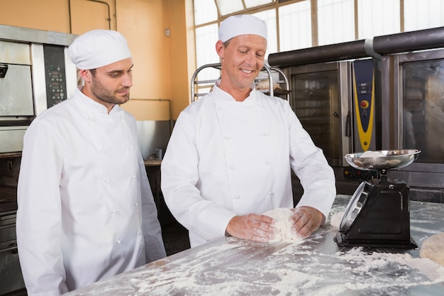 Baker guarda il suo collega che impasta la pasta