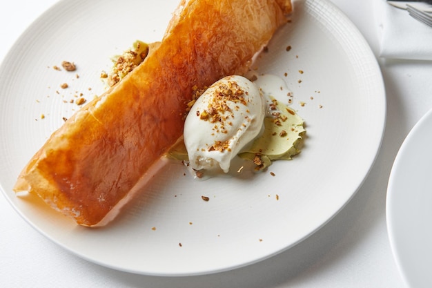 Baklava con pistacchi e gelato su un piatto bianco