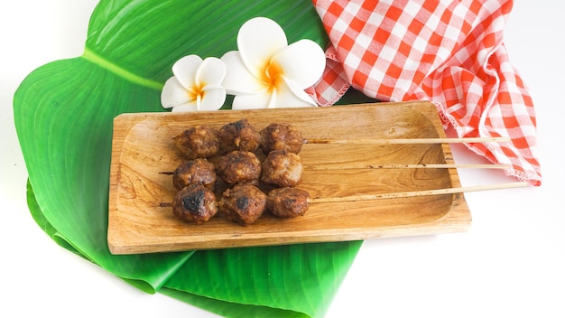 Bakso bakar sono polpette alla griglia indonesiane servite su un piatto di legno