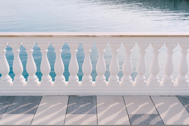 Balaustra in marmo bianco su una terrazza piastrellata in riva al mare