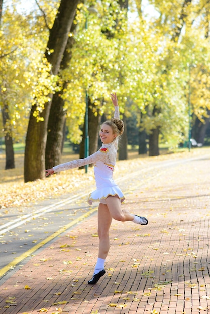 Ballerina che balla in natura tra le foglie d'autunno sulle punte.