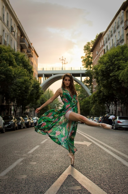 Ballerina che balla in strada con un vestito verde