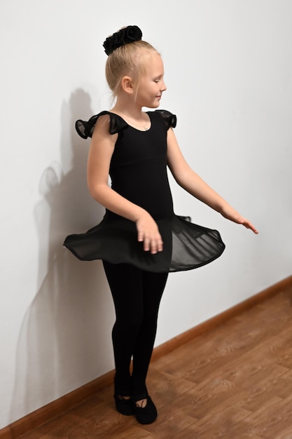 Ballerina del bambino di balletto in posizione in uniforme nera