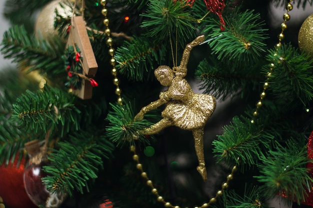 Ballerina dorata che appende su un albero di Natale. Sfondo di natale