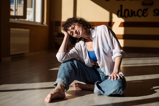 Ballerina giovane ragazza in abiti casual che ballano danza contemporanea all'interno della sala nelle luci del sole del mattino