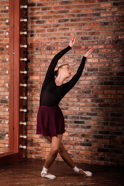 Ballerina in allenamento body scuro in studio