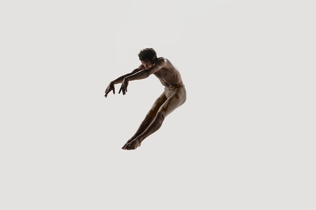 Ballerina moderna. Balletto d'arte contemporanea. Giovane uomo atletico flessibile... Studio girato isolato su sfondo bianco. Spazio negativo.