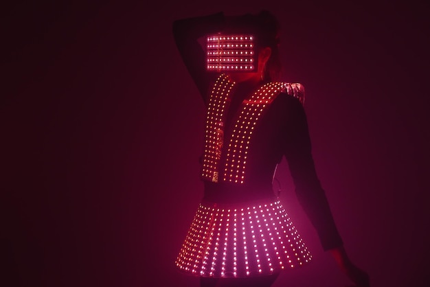 Ballerina sexy della discoteca che balla in un vestito UV alla musica. Feste e balli.