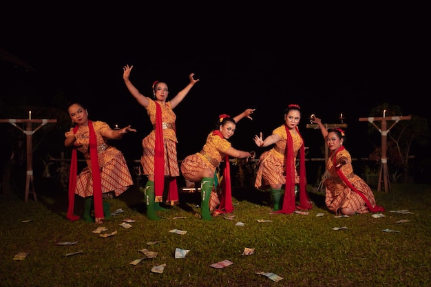 Ballerini giavanesi con bel trucco e costume tradizionale mentre ballano la danza tradizionale sul palco