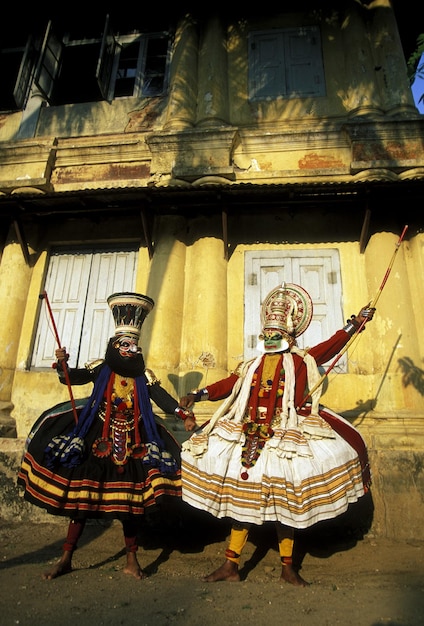 Ballerini Kathakali che ballano contro la vecchia casa