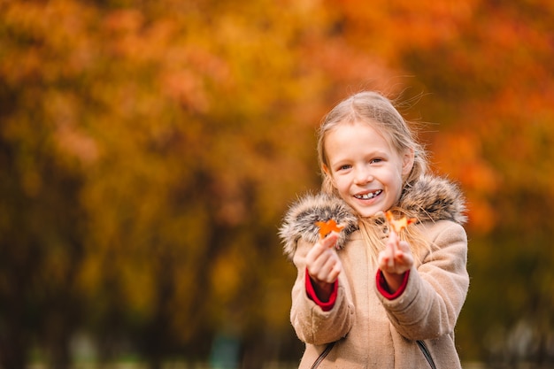 Bambina adorabile al bello giorno di autunno all'aperto