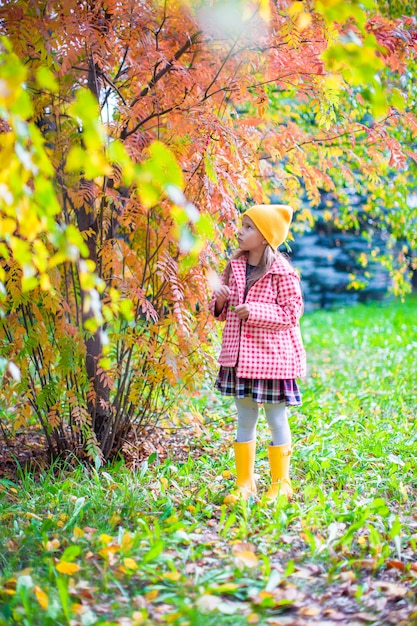 Bambina adorabile al bello giorno di autunno all'aperto