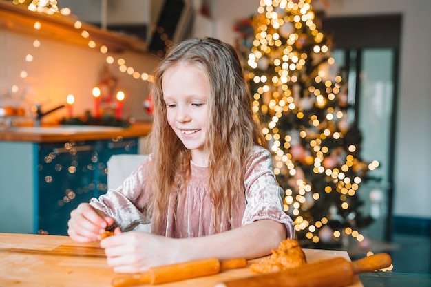 Bambina adorabile che cucina i biscotti del pan di zenzero di Natale