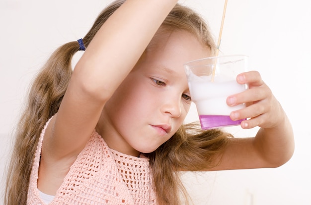 Bambina adorabile che fa il giocattolo della melma, maglie gli ingredienti per il giocattolo fatto da sé popolare.